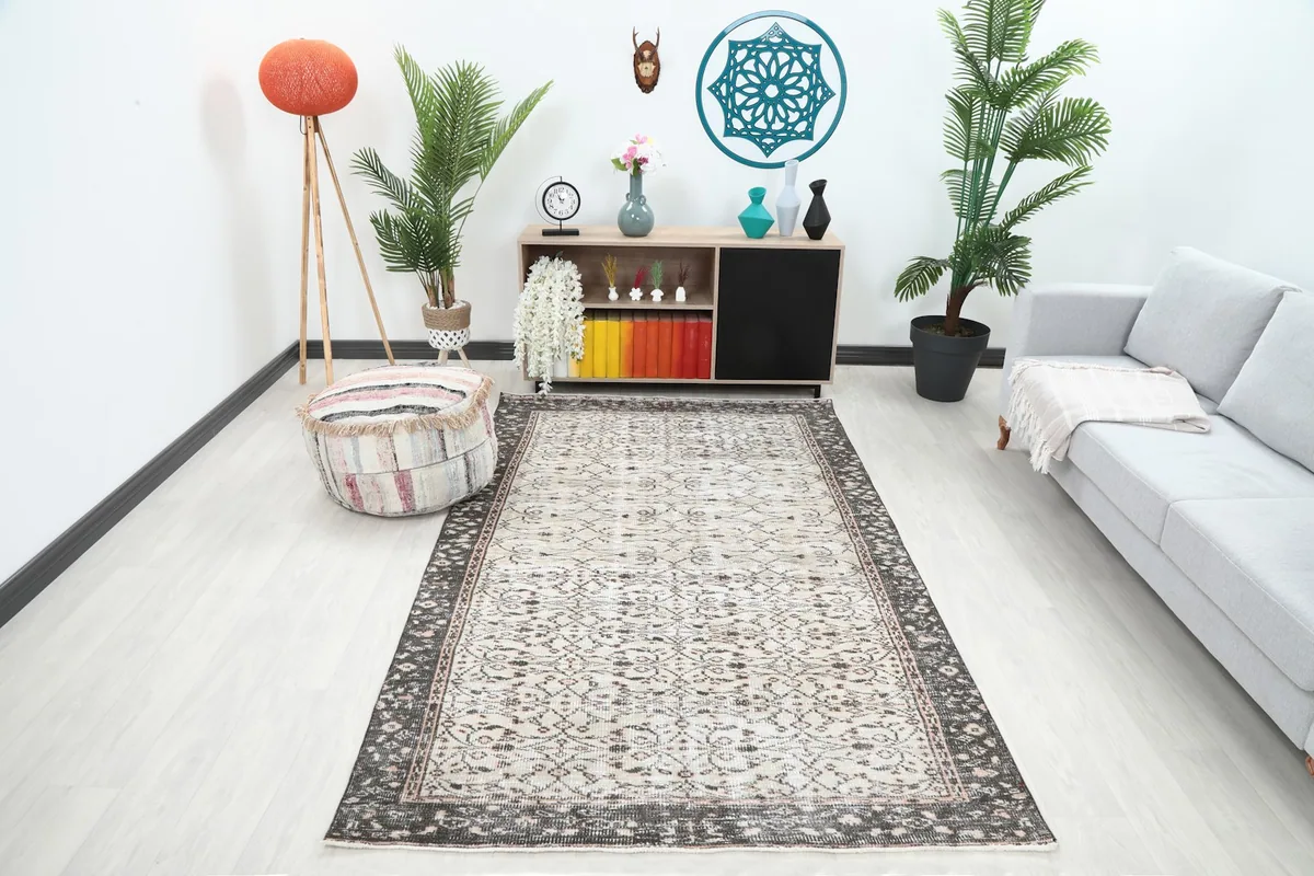 Ivory and charcoal rug placed in a modern living room setting with a gray sofa.