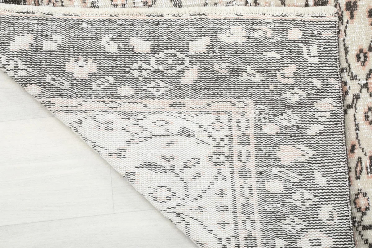 Close-up of the folded corner, showing the tightly woven cotton foundation of the rug.