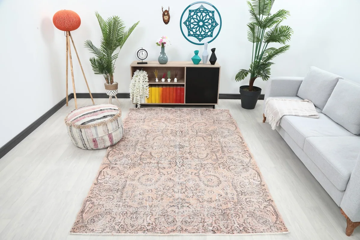 Vintage rose and gray rug displayed in a modern living room setting with a gray sofa