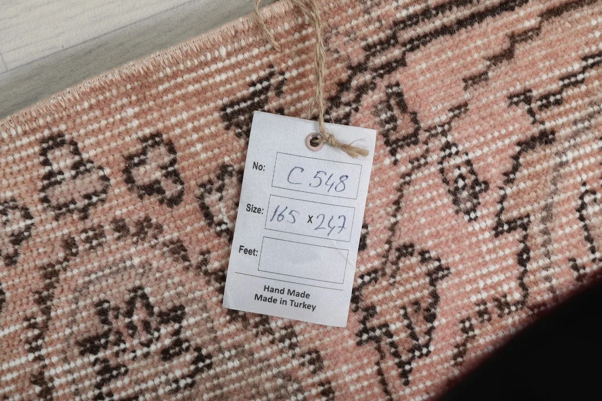 Close-up of the product tag attached to the rug, showing size and handmade in Turkey details