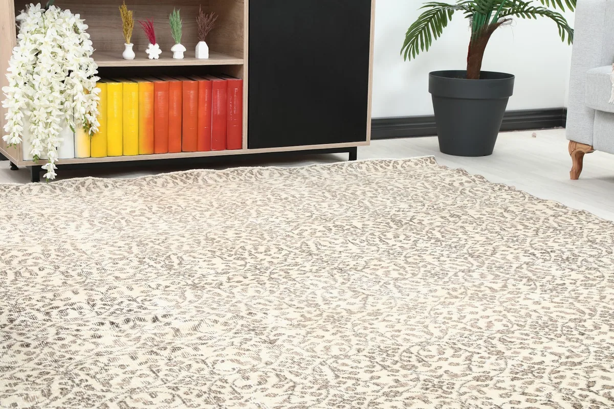 Close-up of the rug's pattern on the floor next to a bookshelf in a room