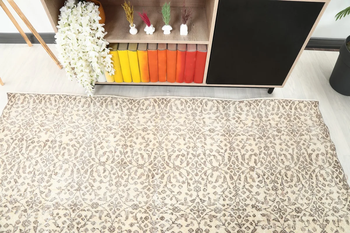 Top-down view of the rug's pattern extending towards a cabinet in a room