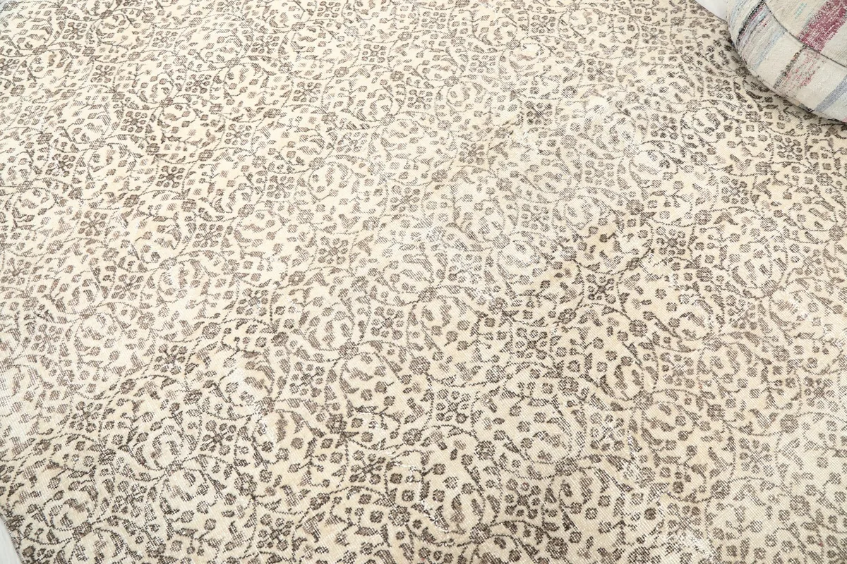Detailed view of the repeating charcoal floral and geometric pattern on ivory background