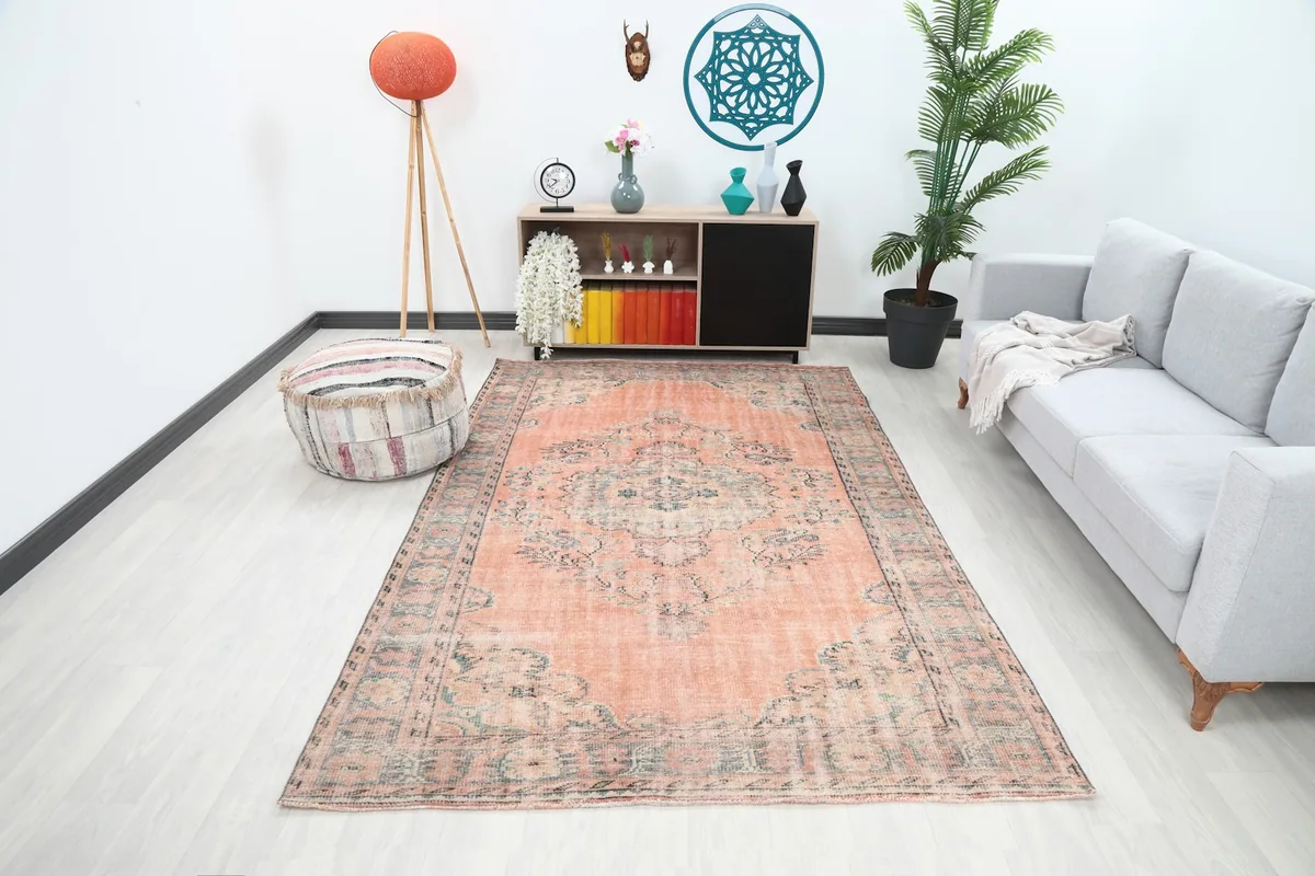 Vintage Anatolian wool rug displayed in a room setting with a sofa and decor
