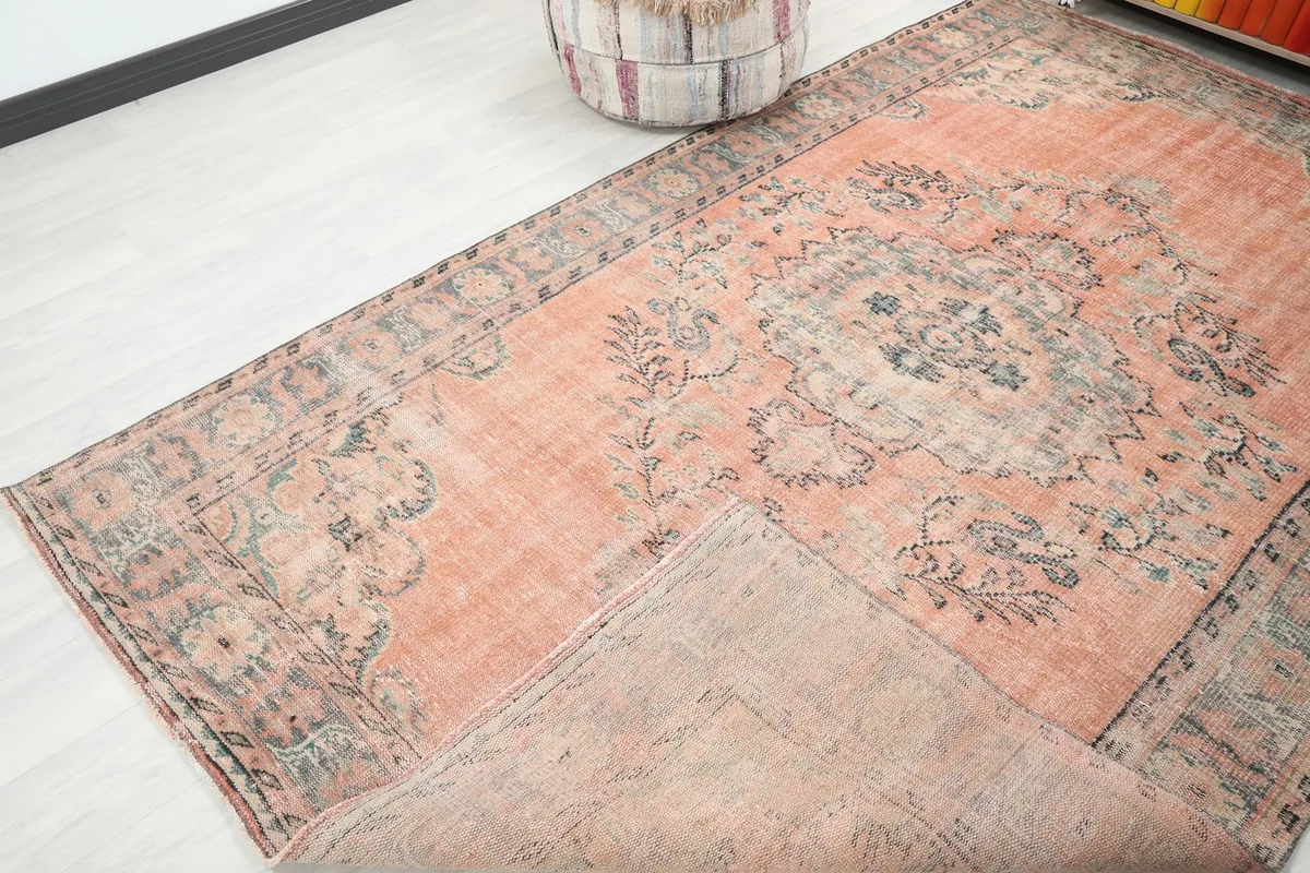 View of the rug with a corner folded back, showing the cotton foundation and reverse side