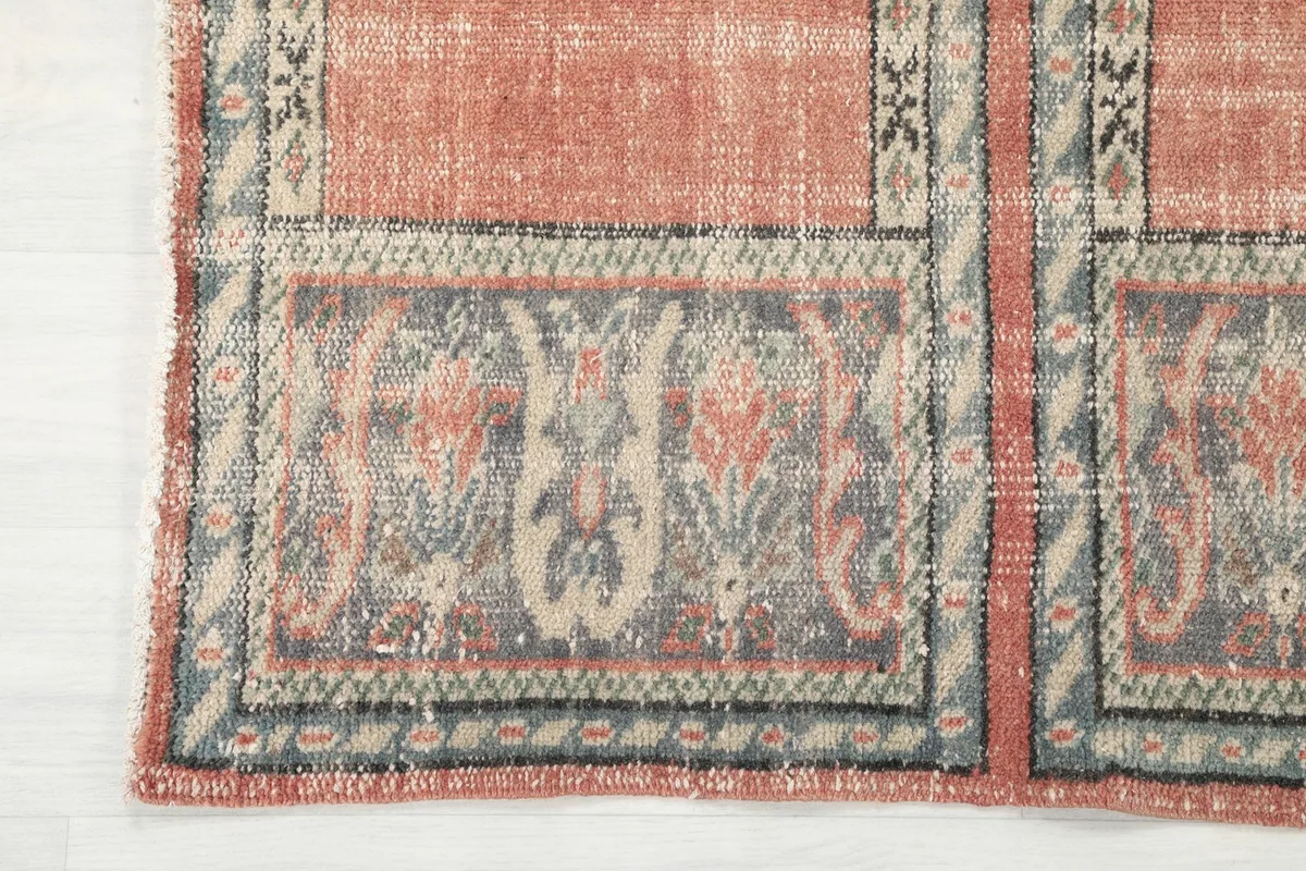 Close-up of the rug's border and end, showing the intricate gray and beige patterns