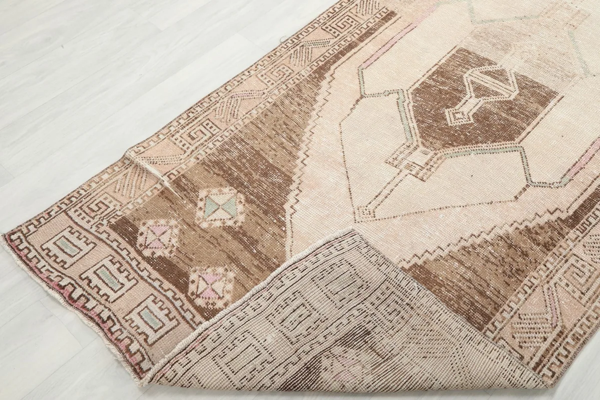 View of the rug folded to show the flexibility and construction, highlighting the wool pile and cotton foundation