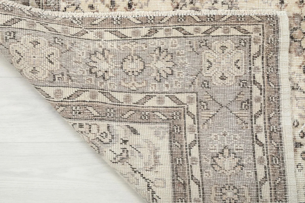 Close-up of the back of the rug, showing the cotton foundation and hand-knotted wool construction.
