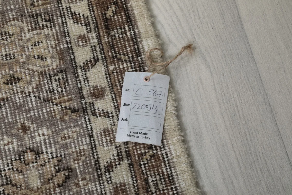 Tag displaying the rug's dimensions (220 x 314 cm) and origin as handmade in Turkey.