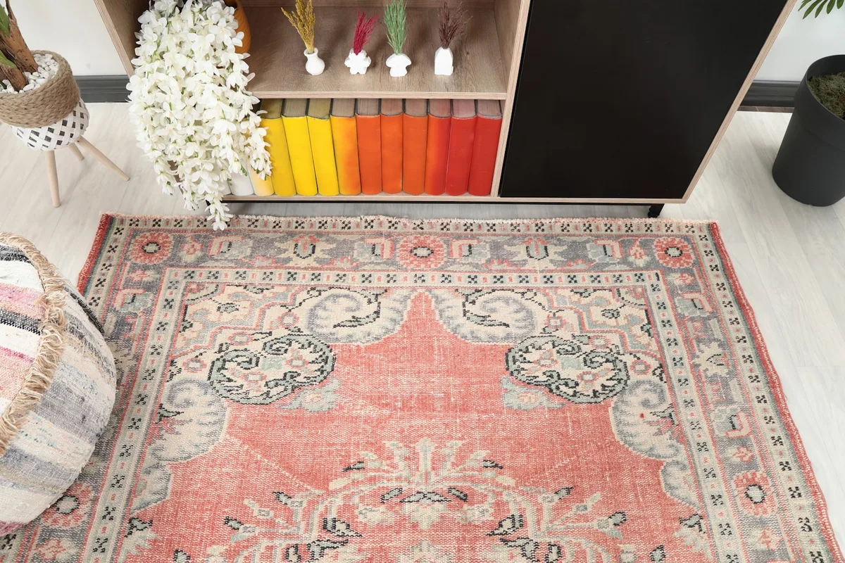 Overhead detail of the top portion of the rose vintage rug, showing the border and field patterns