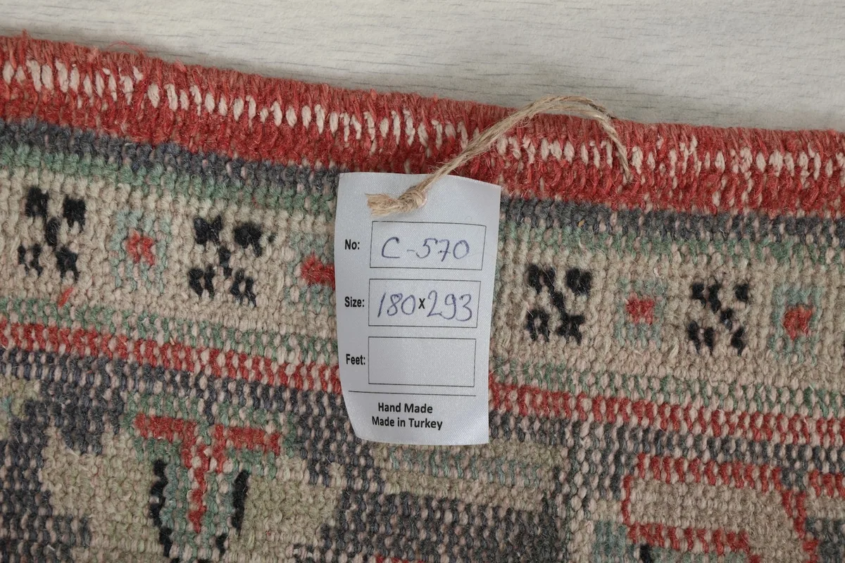 Close-up of the rug's edge, showing the hand-made tag with size information and origin