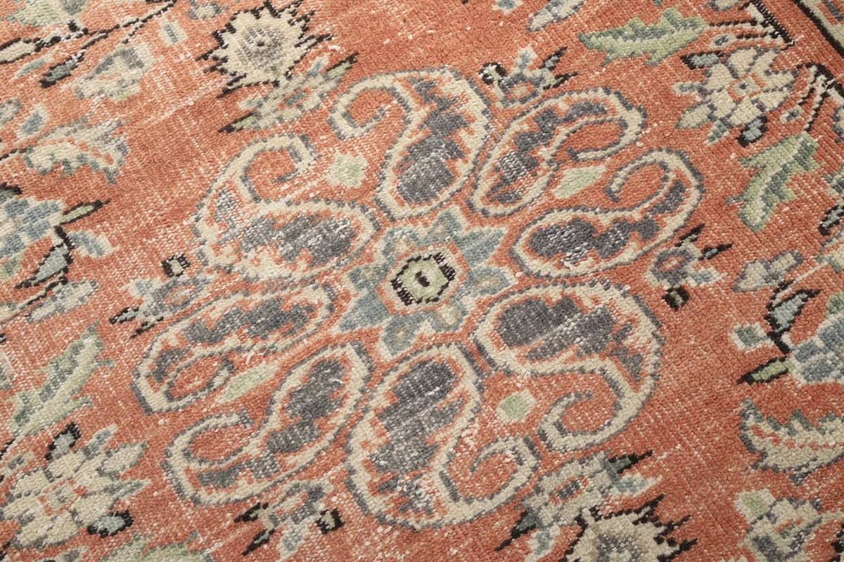 Close-up of the hand-knotted wool pile and the subtle color variations within the medallion design.