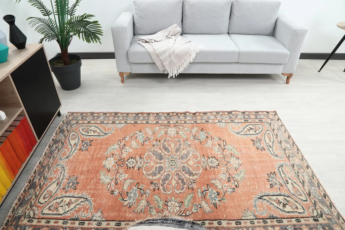 Overhead view of the vintage rug in a room, highlighting the central floral medallion.
