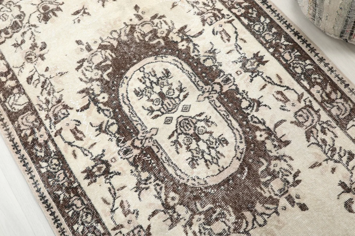 Close-up detail of the central medallion and surrounding floral patterns, showing the wool pile.