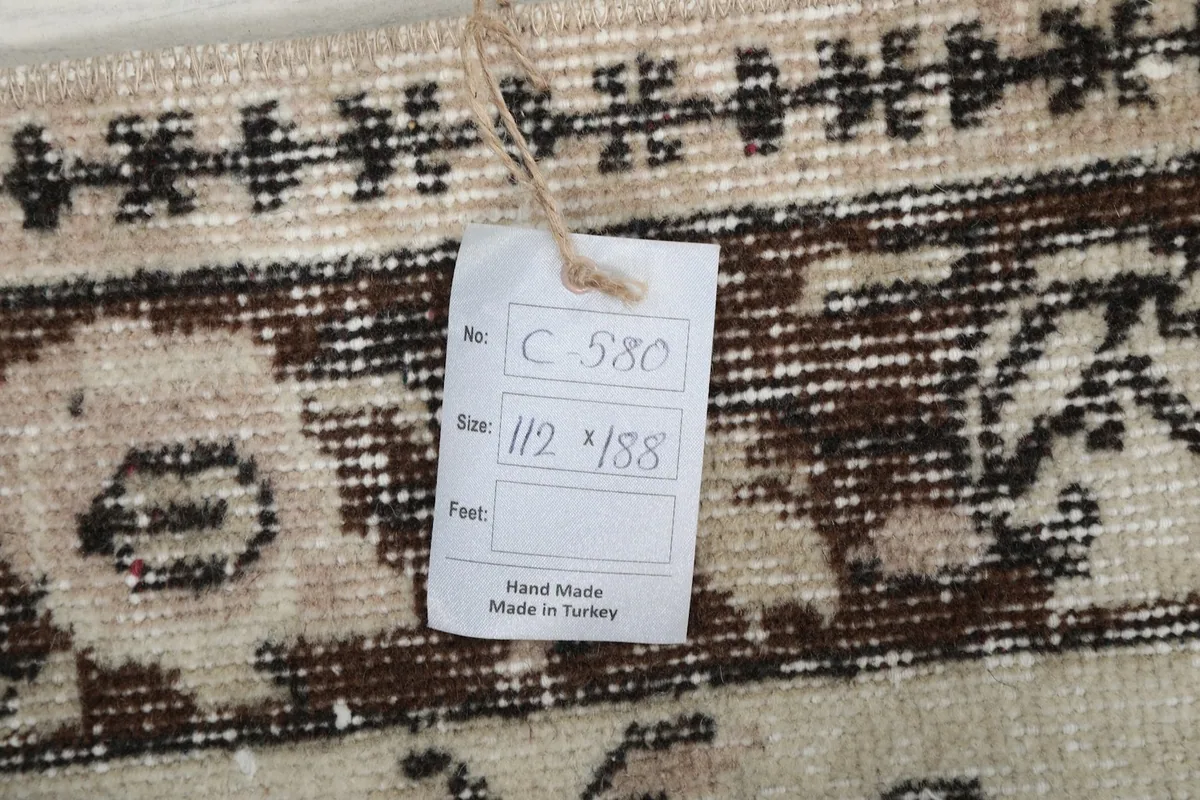 Close-up of the product tag attached to the rug, displaying its size and origin details.