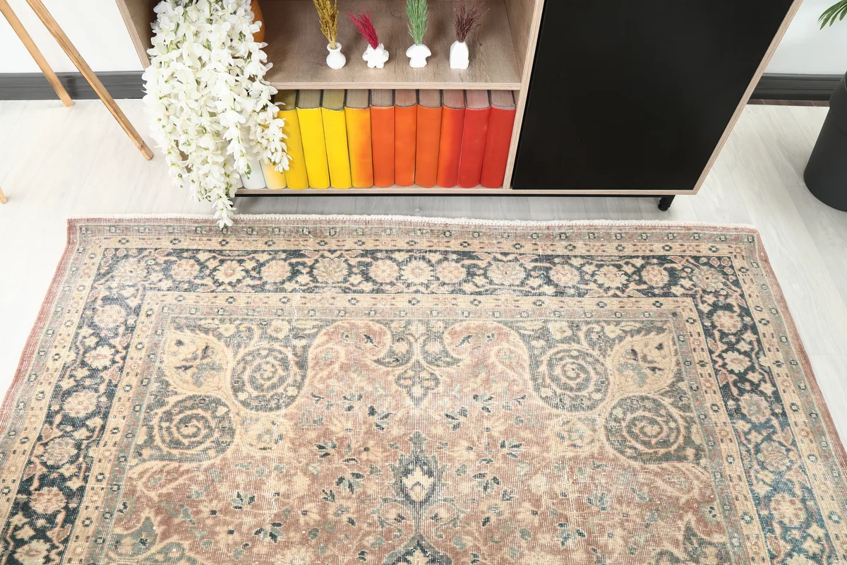 Detailed shot of the Faded Rust Medallion Anatolian Rug's upper field and border, revealing faded rust and navy motifs.