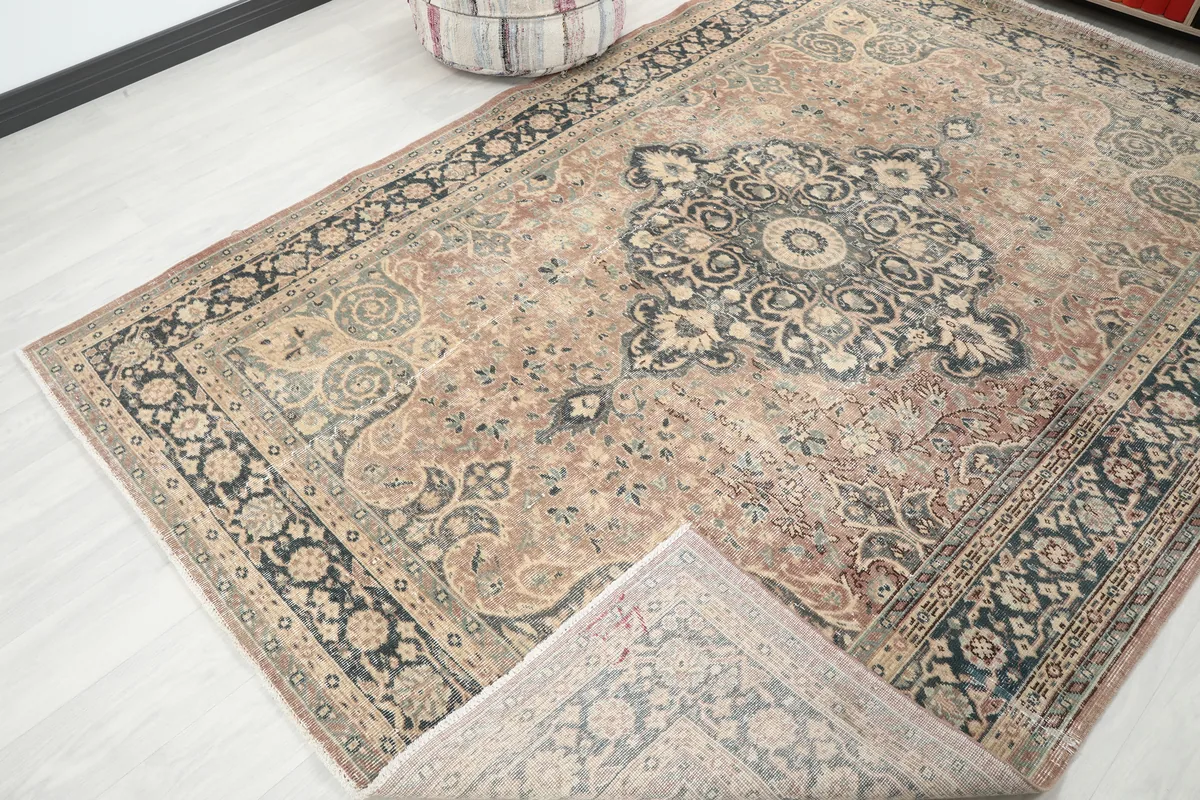 Faded Rust Medallion Anatolian Rug with a corner folded back, revealing the wool pile and cotton foundation.