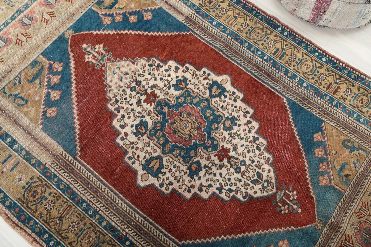 Detailed view of the central red field and the intricate blue and ivory medallion