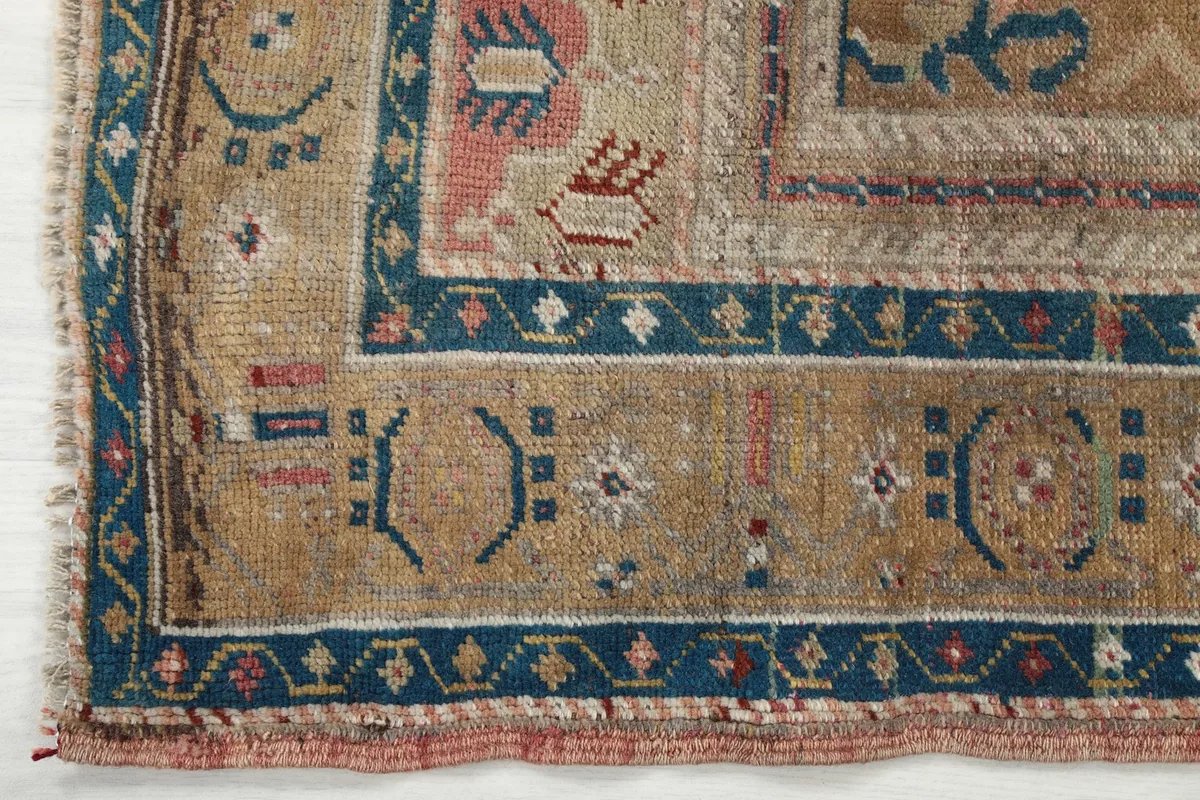Detailed shot of the beige outer border with geometric designs and blue accents
