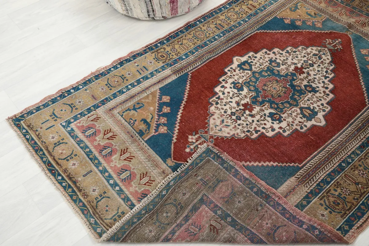 Rug partially folded, revealing the reverse side and the hand-knotted structure