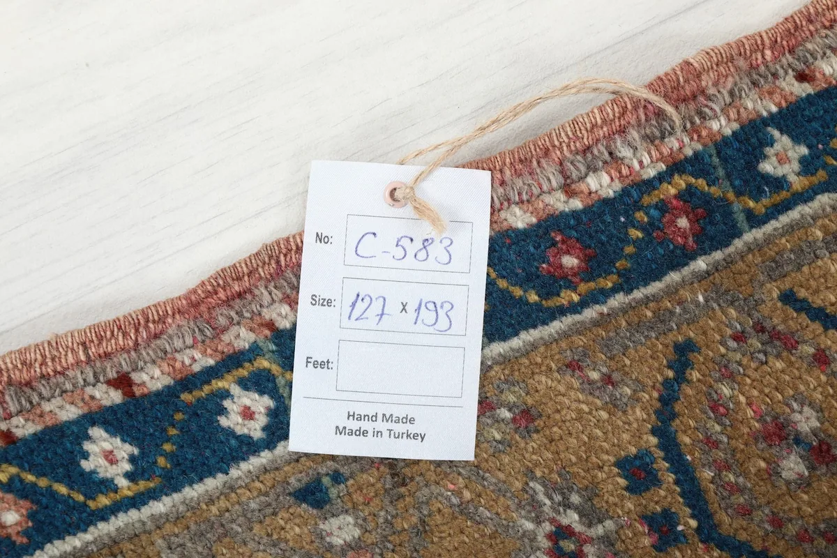 Tag displaying the rug's measurements in centimeters and indicating it's handmade in Turkey