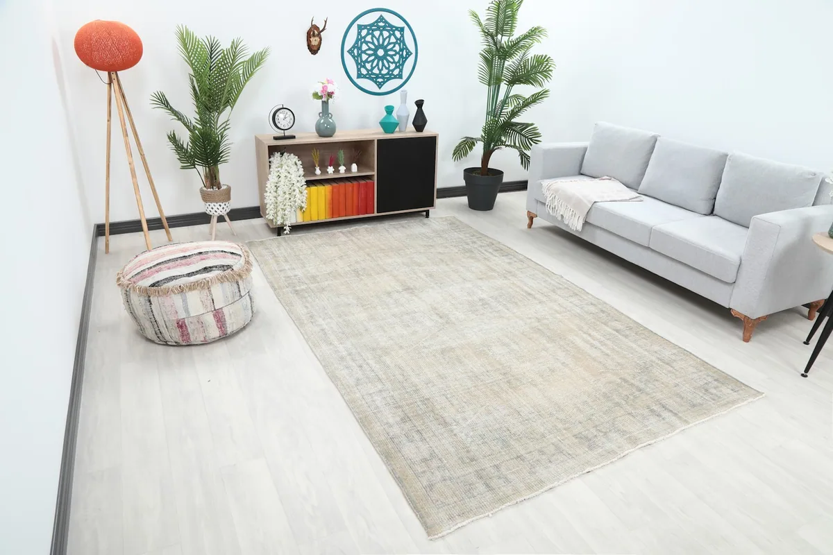 Angled view of the Faded Ivory Geometric Area Rug in a living space, showing its placement relative to furniture