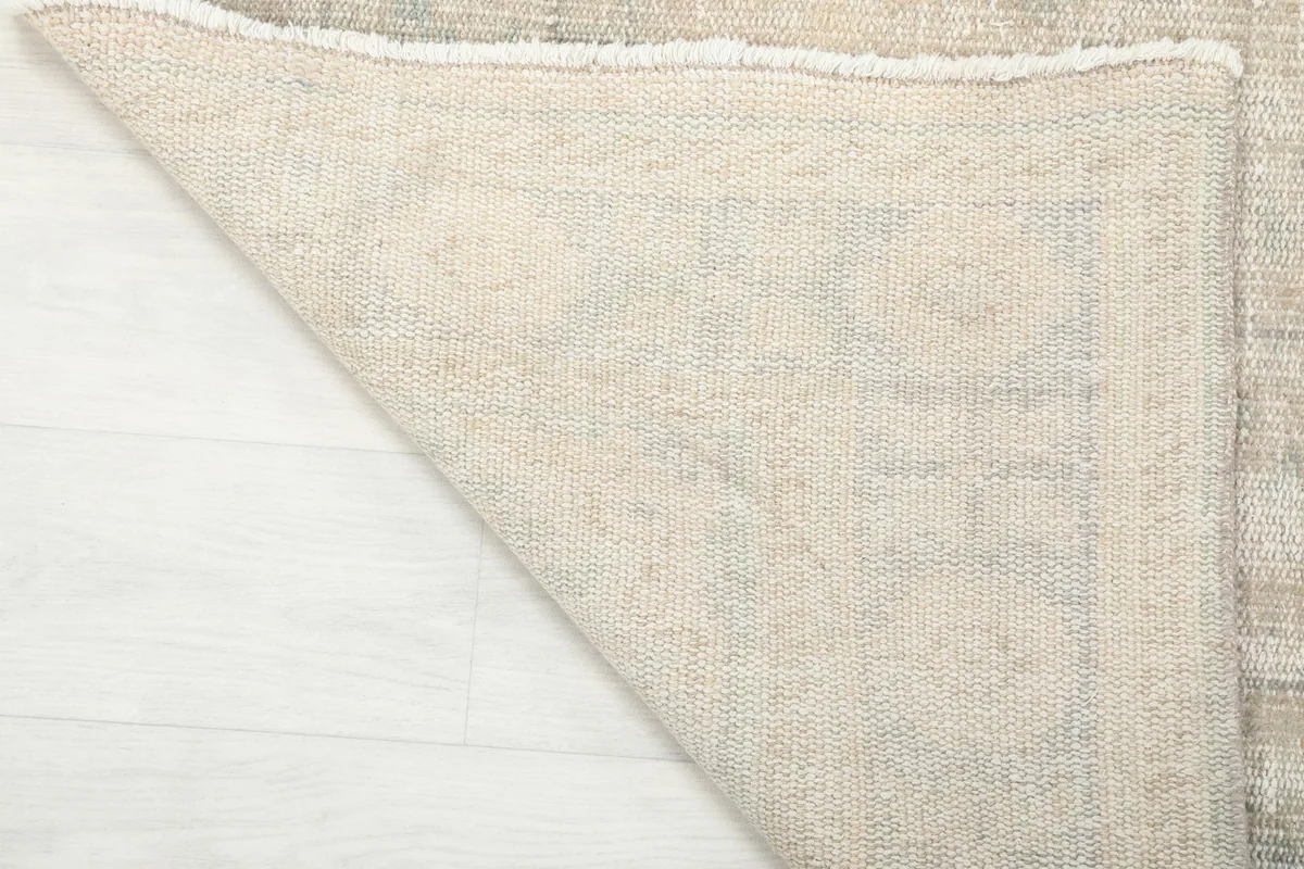 Underside of the vintage rug, showing the cotton foundation and fine knotting of the wool pile