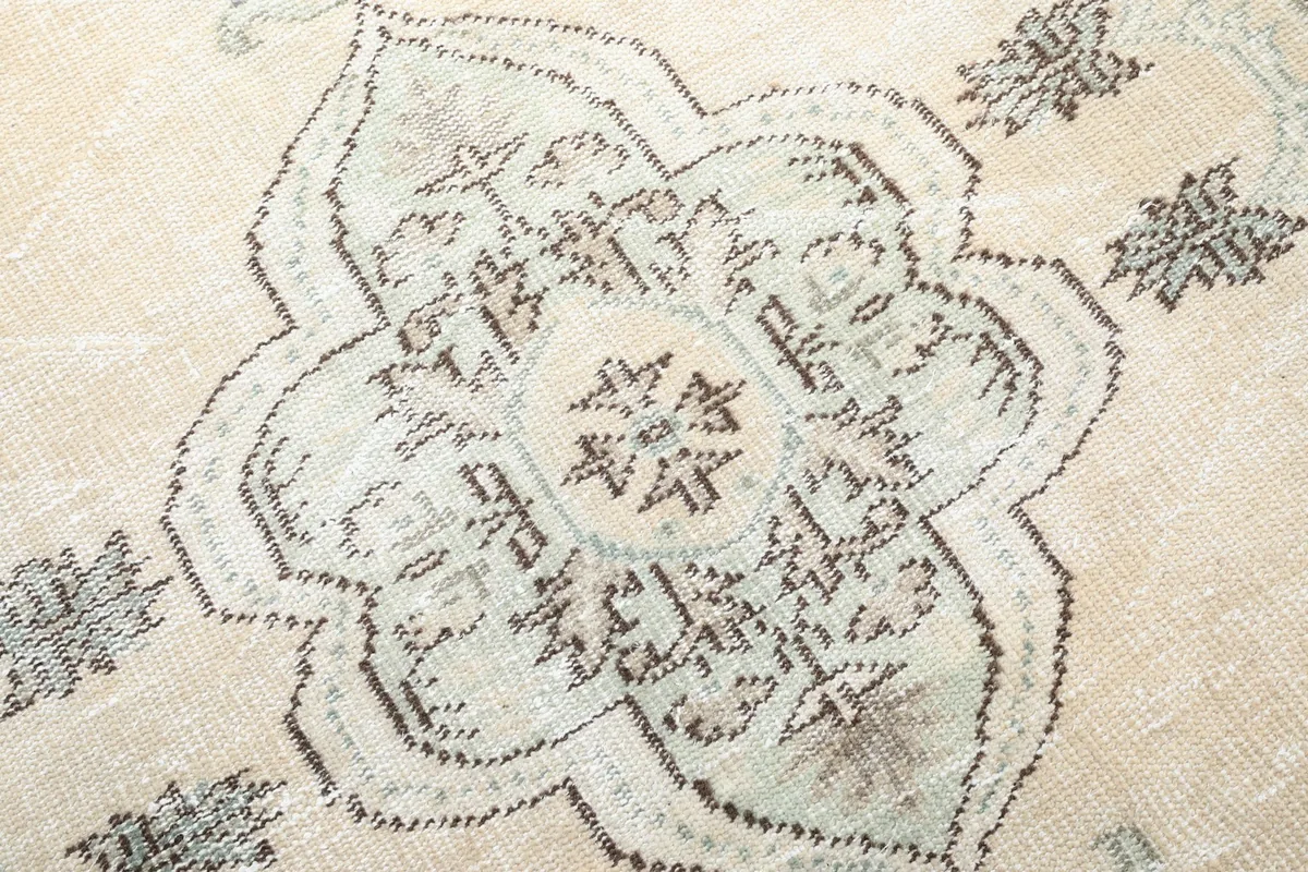 Extreme close-up of the intricate design within the central medallion of the rug.