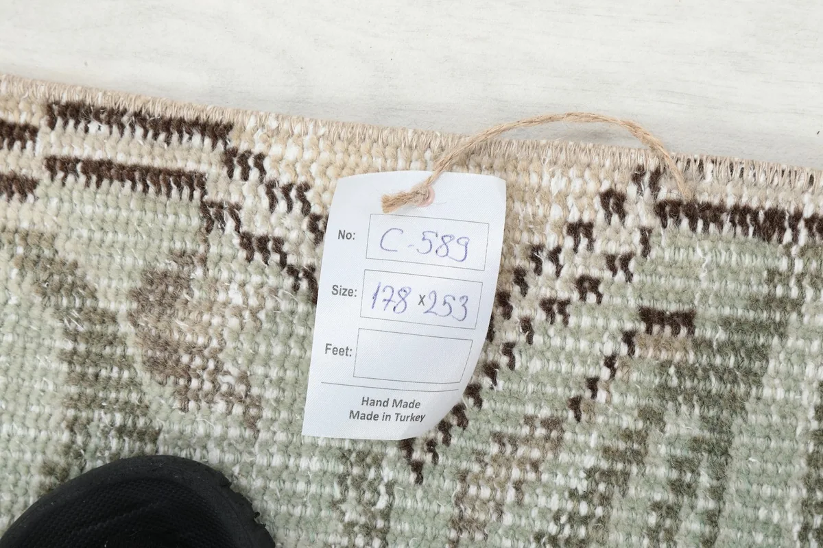 A tag displaying the rug's dimensions and origin, placed on the back of the rug.