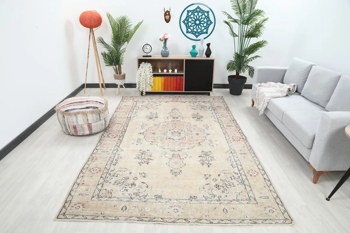 Vintage Anatolian rug displayed in a bright living room setup with a gray sofa