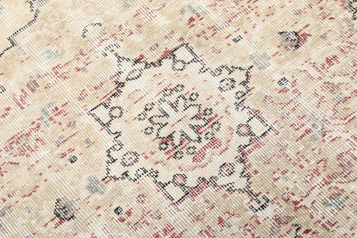 Extreme close-up of the rug's distressed texture and intricate patterns