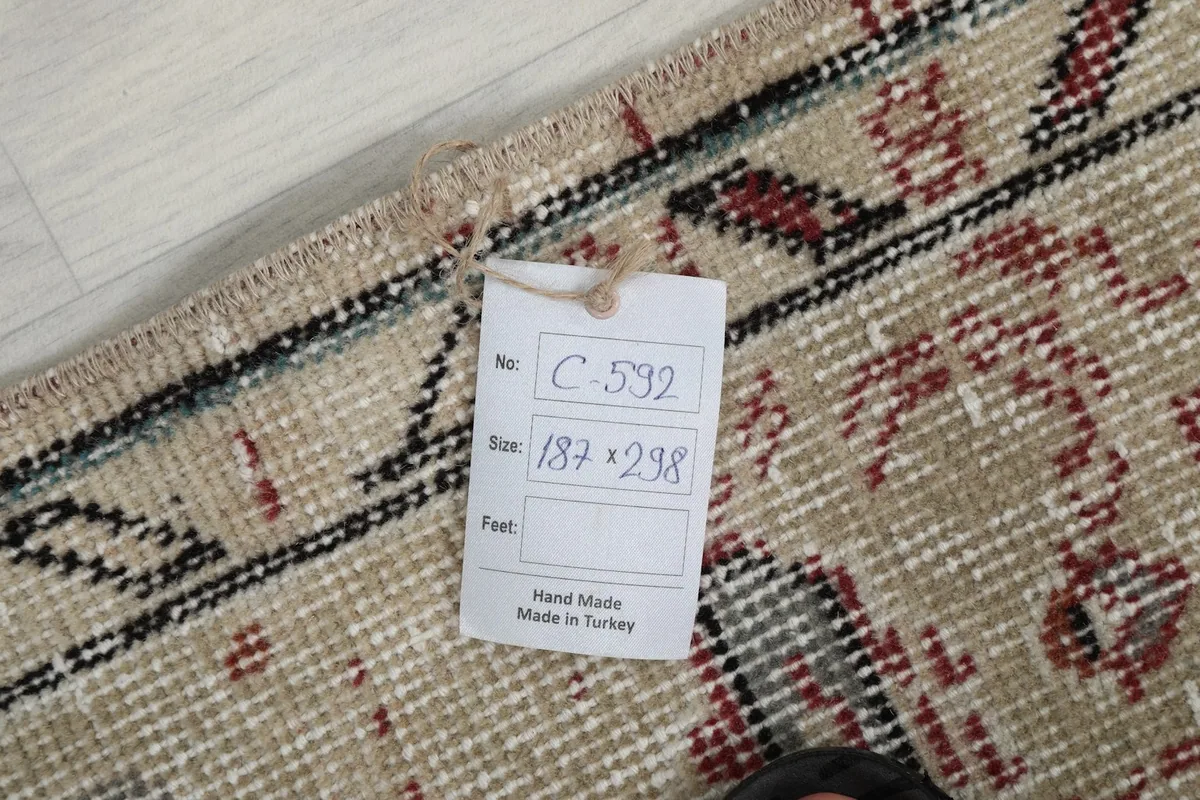 Tag showing the rug's dimensions and origin, attached to the hand-knotted wool pile