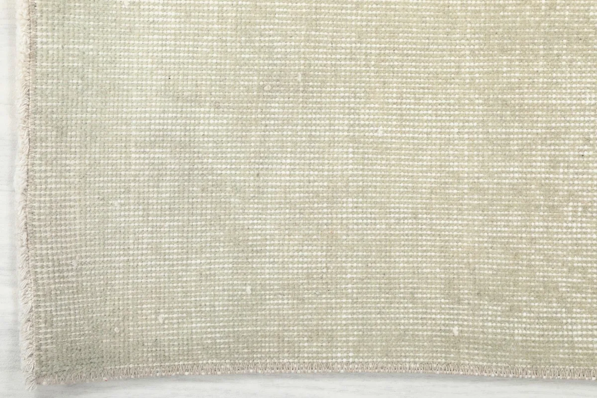 Detail of the rug's edge and fringe, showcasing the tightly woven cotton foundation.