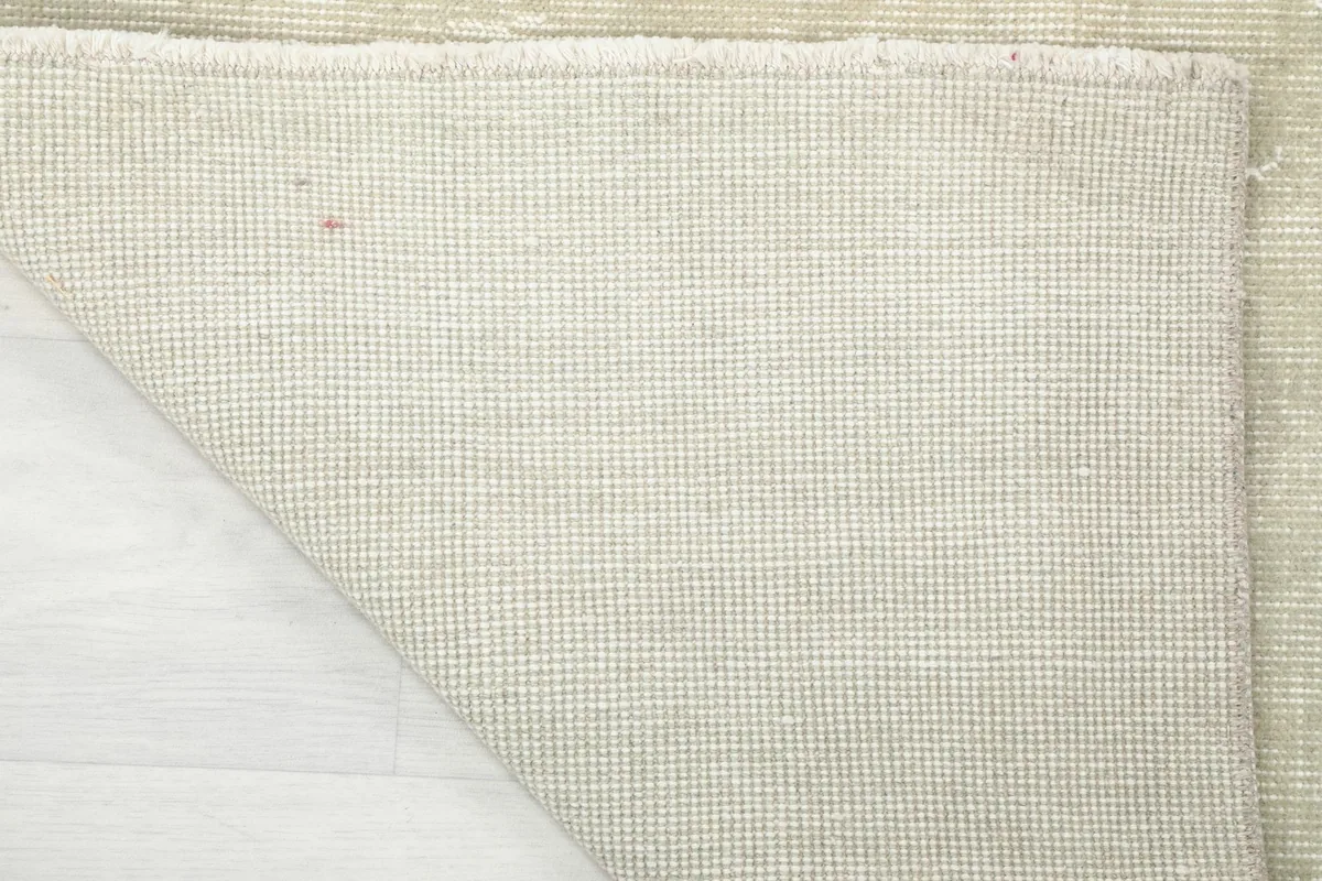 Full view of the rug's backside, showing the intricate grid of the cotton foundation and knots.