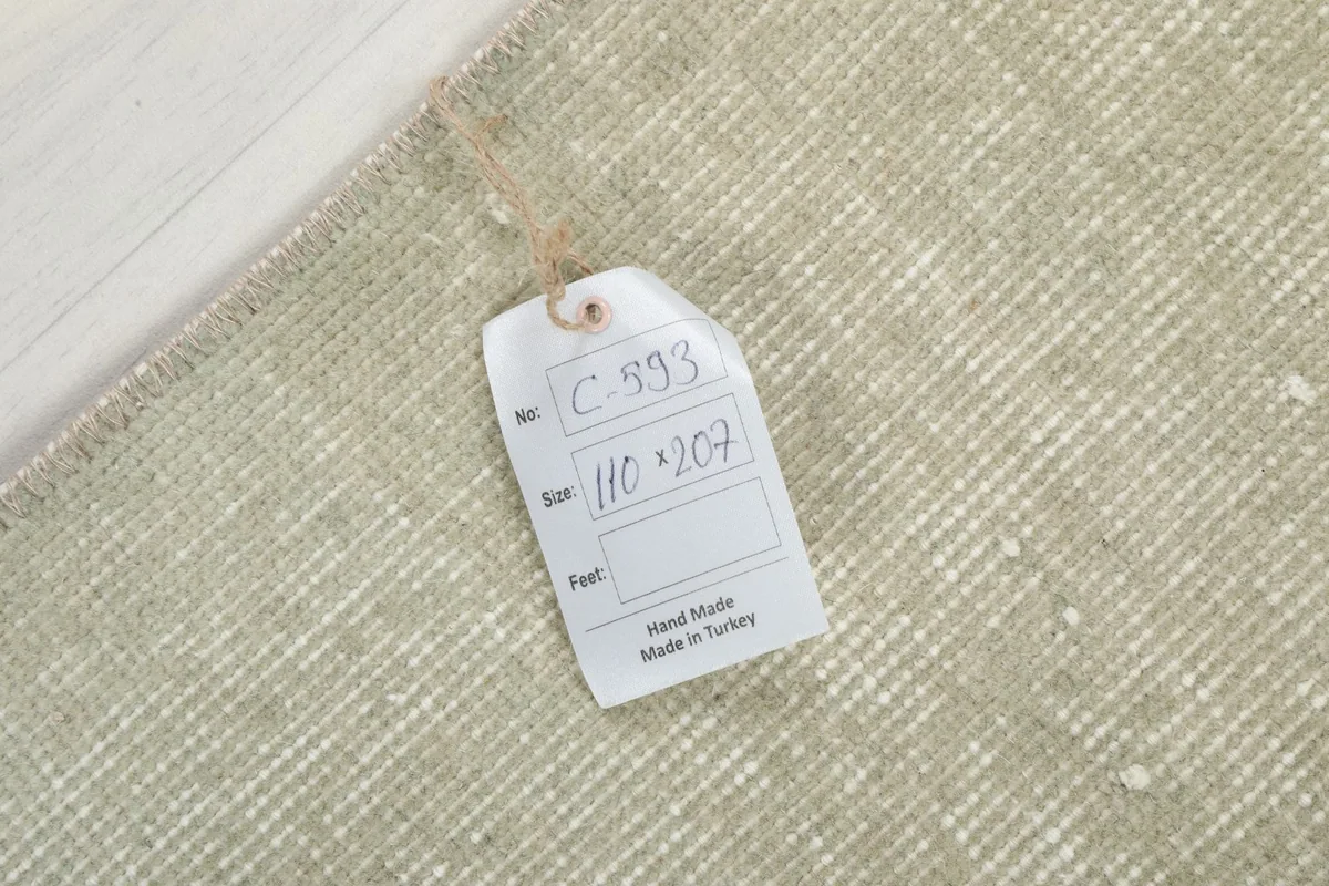 Tag showing the rug's item number and dimensions (110 x 207 cm), confirming it is hand-made in Turkey.