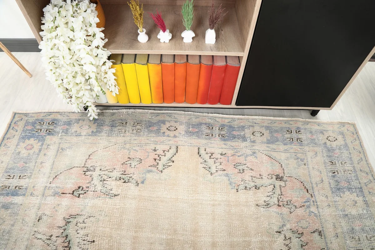 View of the rug's upper section, showing the faded floral patterns and part of the border