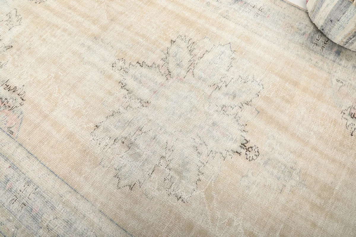 Close-up detail of the central medallion motif, revealing the low pile and subtle wear