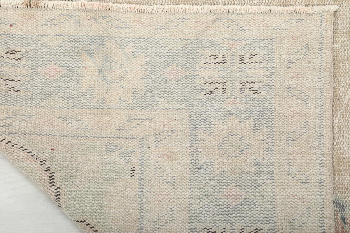 Reverse side of the hand-knotted rug, displaying the tightly woven cotton foundation
