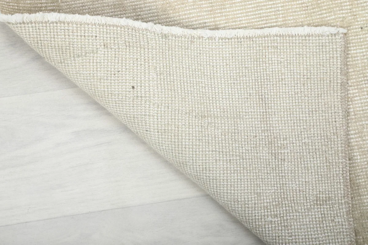 Detailed view of the rug's underside, showcasing the sturdy cotton foundation and craftsmanship.