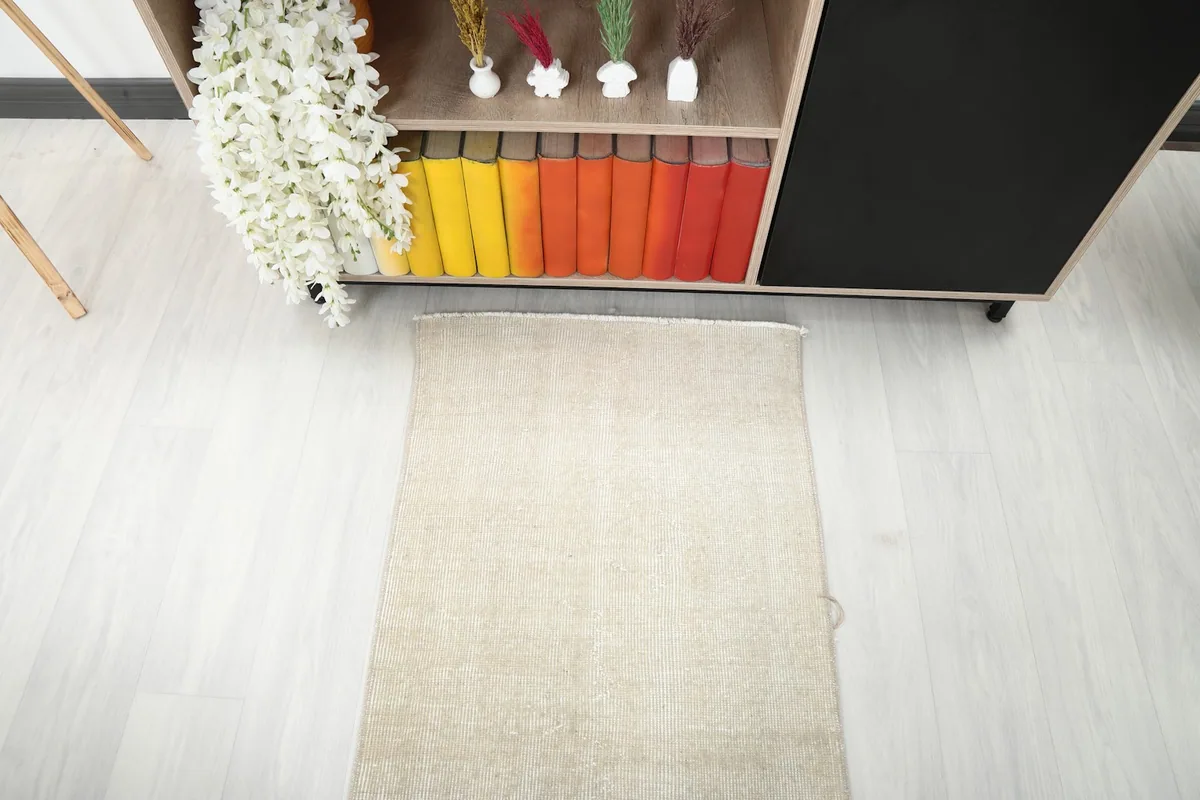 Overhead shot of one end of the cream runner rug, showing its placement near a bookshelf with colorful books.