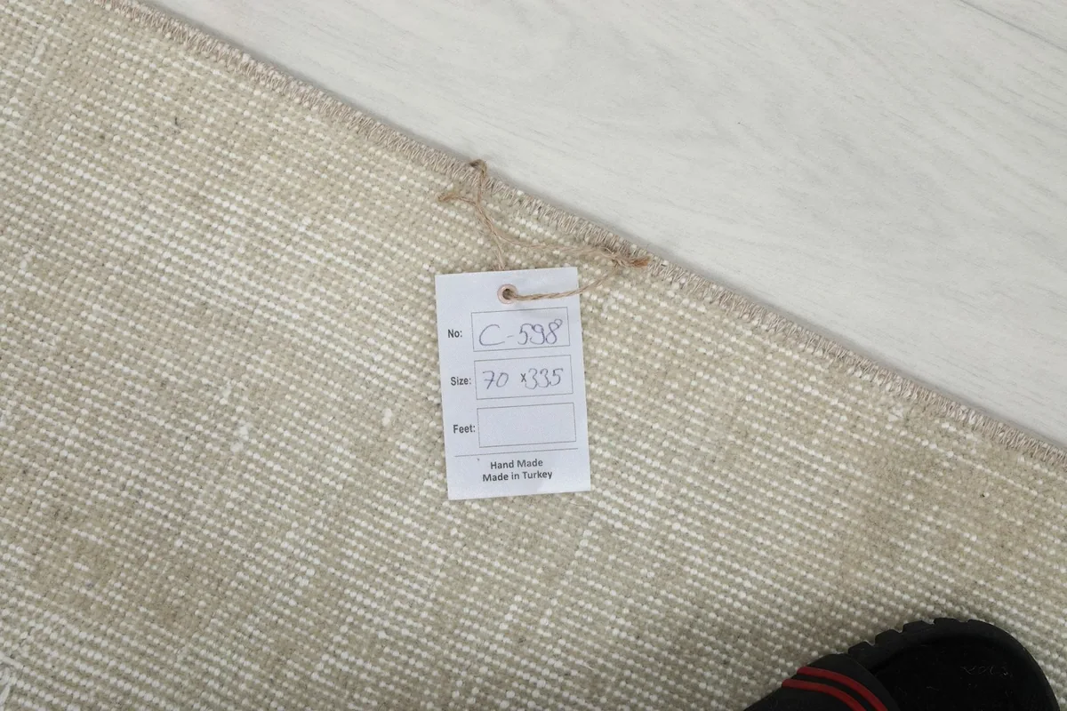 Close-up of the product tag attached to the rug, showing size details and 'Hand Made in Turkey' label.