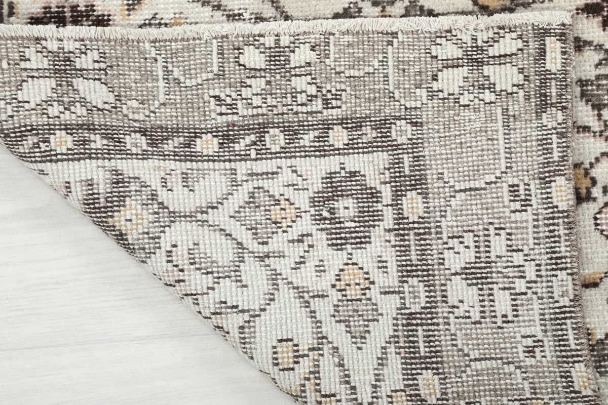 Underside of the rug showing the cotton foundation and hand-knotted structure