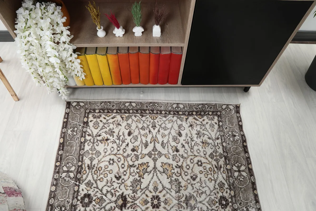 Overhead shot of the rug's cream field and brown border, showing the full pattern