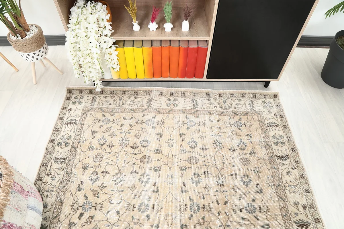 Detail of the rug's ivory field and gray floral motifs within a room environment
