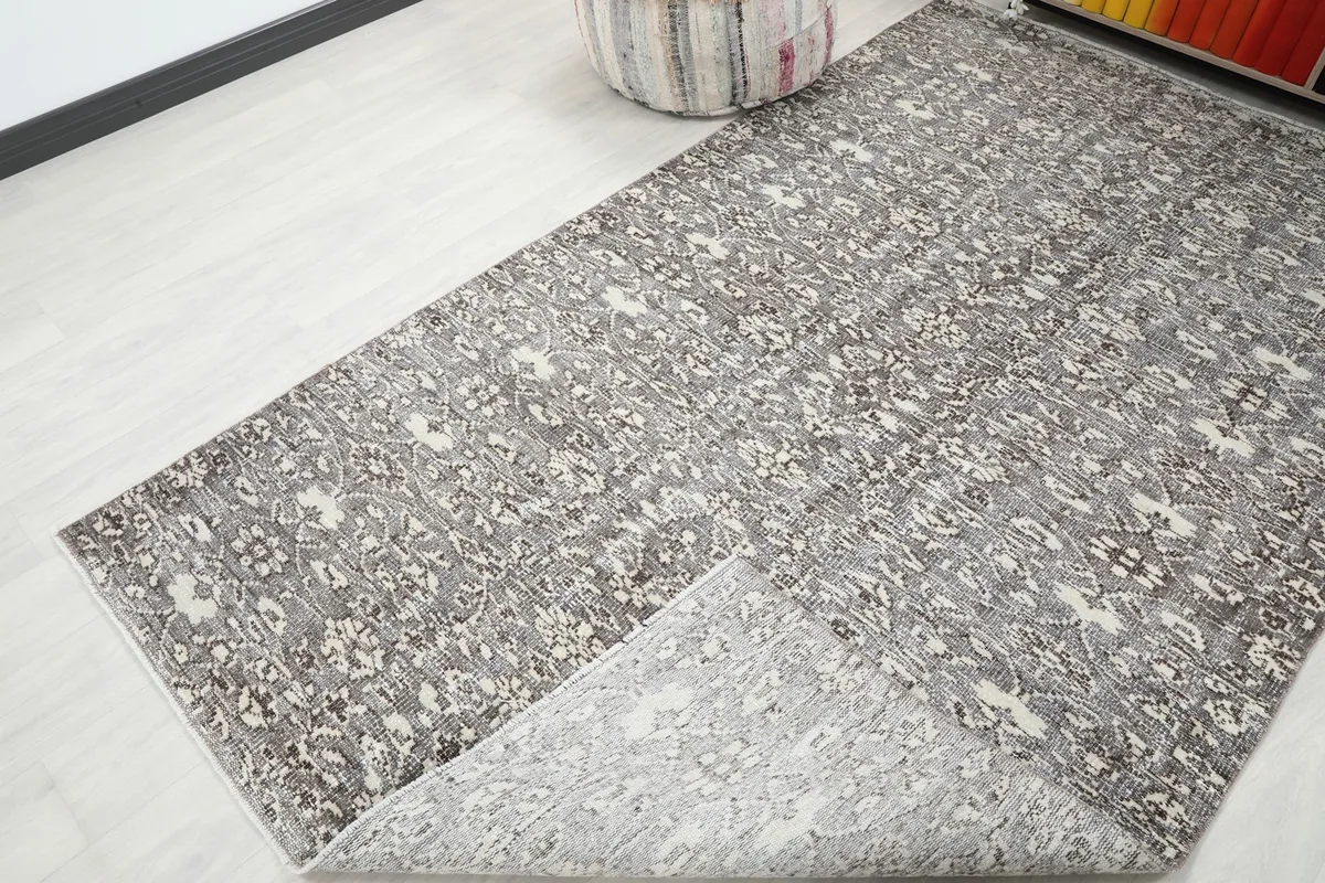 View of the rug folded back to show the reverse side and construction