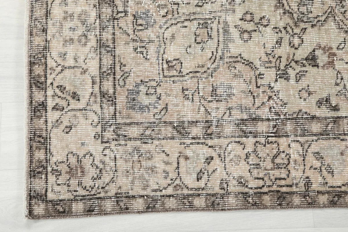 Corner detail of the rug's border pattern in gray and cream