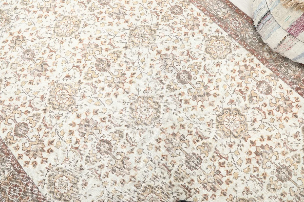 Close-up of the ivory field with brown and tan floral motifs and subtle distressing