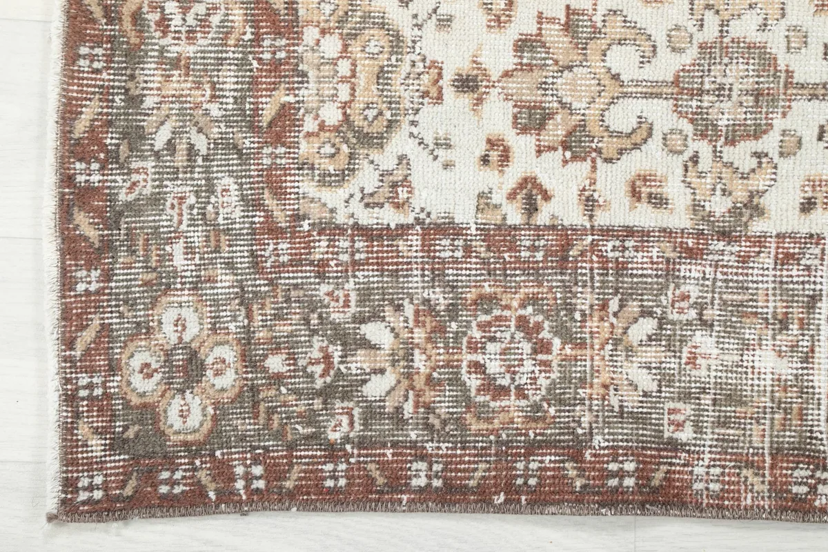 Corner detail of the rust border and distressed outer edge of the vintage Anatolian rug
