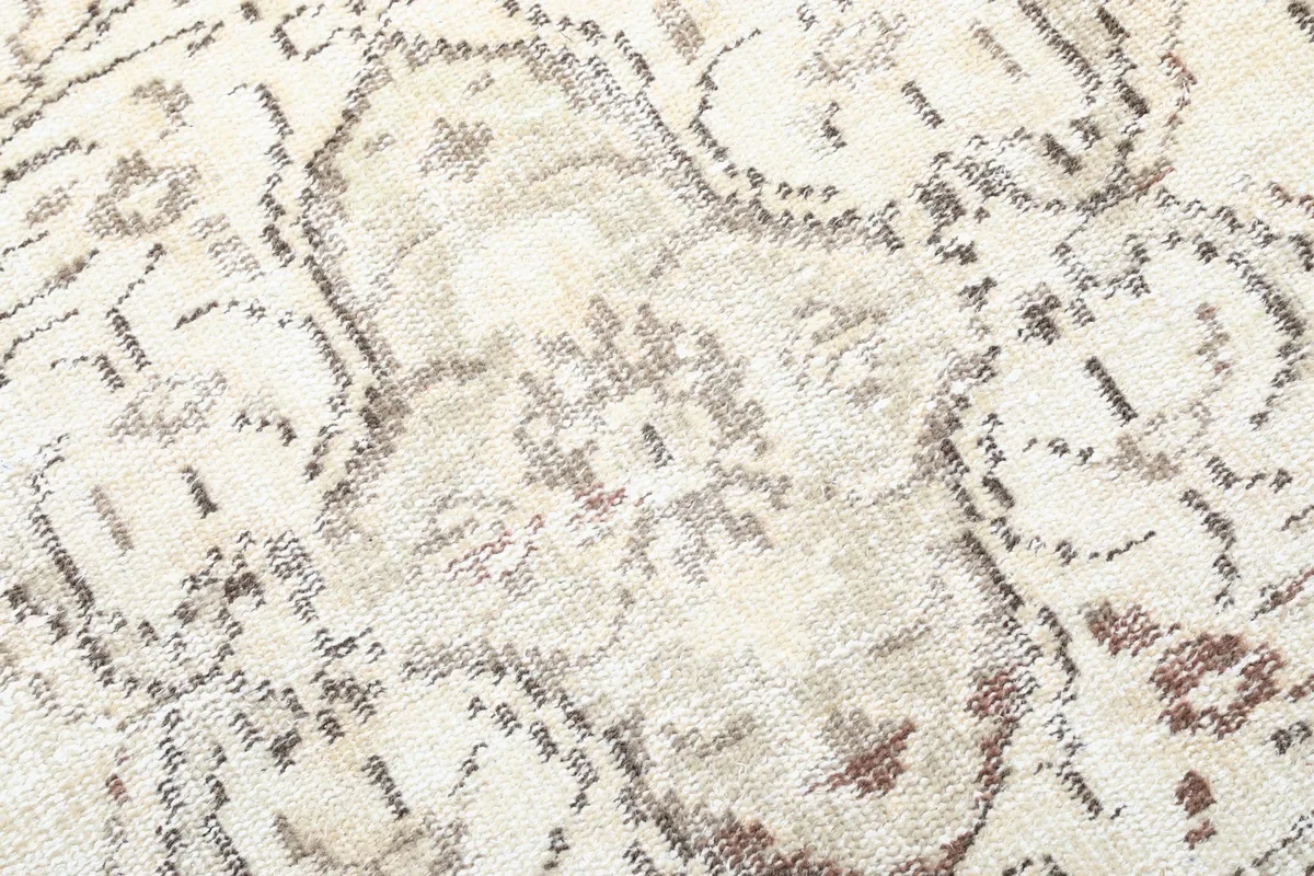 Close-up of the faded brown and rust patterns, showcasing the rug's vintage character