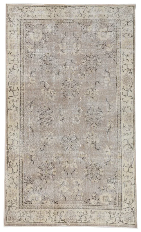 Full top view of the 4'11" x 8'5" vintage Anatolian rug with tan field and floral motifs